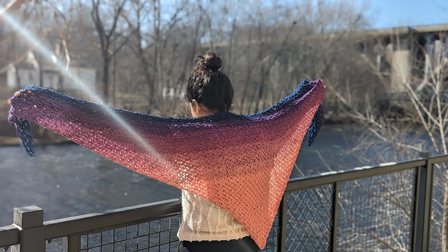 Ombre triangle shawl held open in the sun